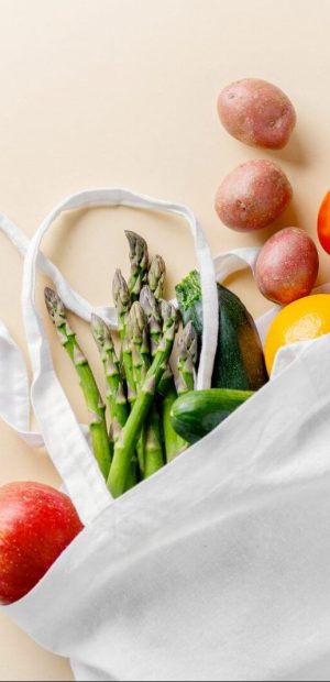Different vegetables in textile bag on beige Zero waste concept. Vegetables in textile bag. No plastic. Bright Background. Clever consuming, healthy planet concept.